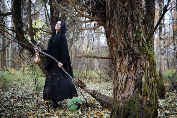 Une femme en costume de sorcière dans une forêt — Photo