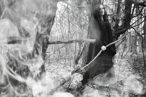 Femme en costume de sorcière dans une forêt dense — Photo