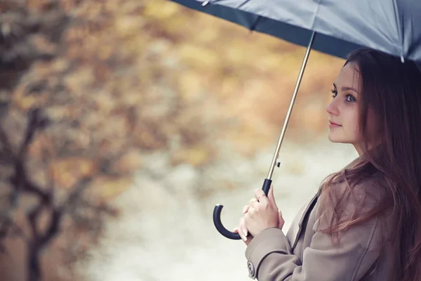 Outono tempo chuvoso e um jovem com um guarda-chuva — Fotografia de Stock