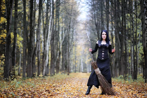 A woman in a witch suit in a forest — Stock Photo, Image