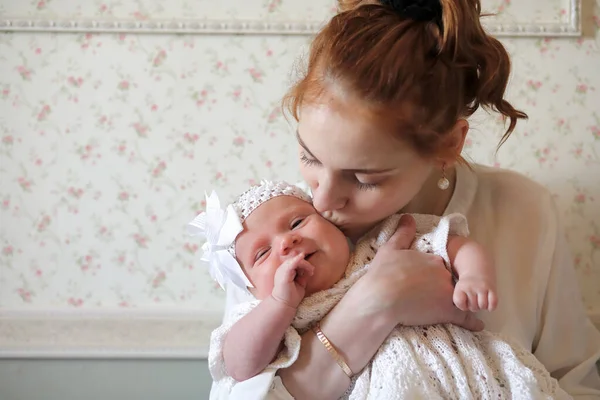 Симпатичная молодая мать с новорожденной дочерью на руках — стоковое фото