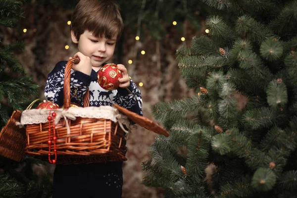 A little child by the New Year tree. Children decorate the Chris — Stock Photo, Image