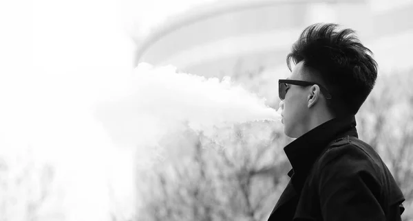 Black White photo of Asian young man outdoors posing