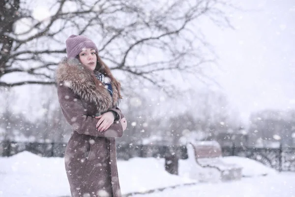 Κορίτσι σε χειμερινό πάρκο σε χιονόπτωση — Φωτογραφία Αρχείου
