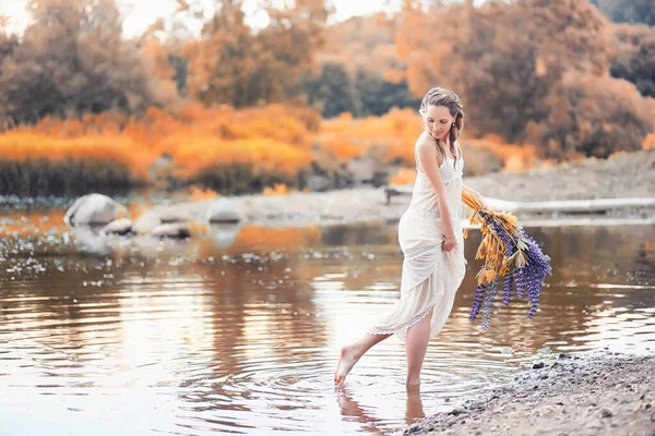 Meisje met een boeket van bloemen in de herfst — Stockfoto