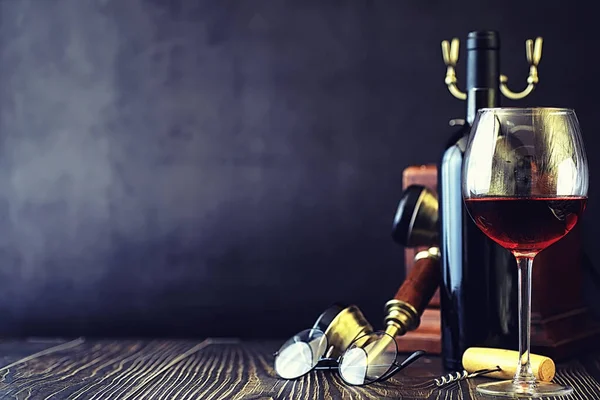 Un bicchiere di vino rosso secco sul tavolo. Bottiglia scura e vetro di w — Foto Stock