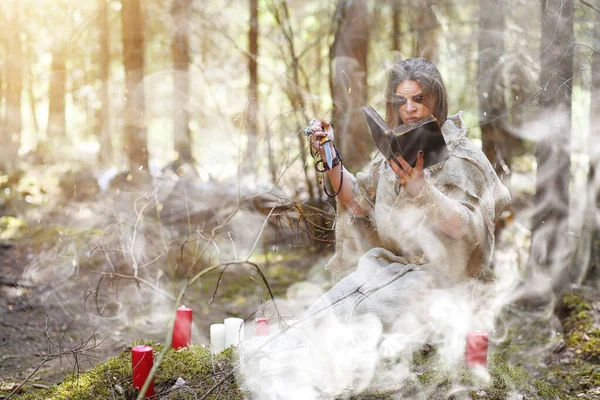 Un homme en soutane passe un rituel dans une forêt sombre — Photo