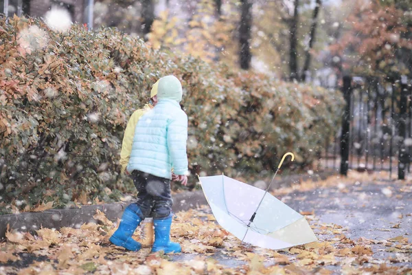 Kinder spazieren im Park im ersten Schnee — Stockfoto