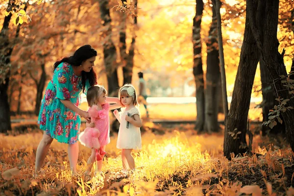 Mom with two daughters twins autumn — Stock Photo, Image