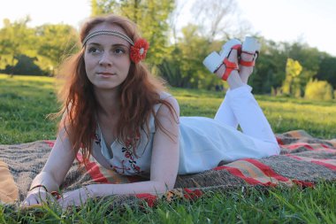 Bir sonbahar Parkta yürümek bir kız. Kızıl saçlı genç kız