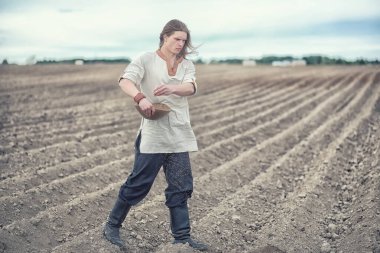 Genç bir köylü tahıl alanıyla sows