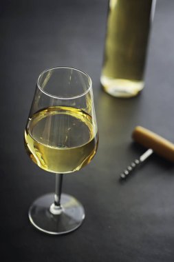 Masada şeffaf beyaz şarap şişesi var. Beyaz şarap!