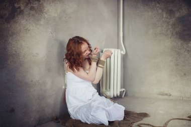 Genç kız yere bağlı. Kaçırılan kız. Kurban o