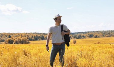 Genç bir adam doğal olarak dolaşıyor. Sırt çantasıyla seyahat eden