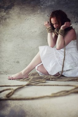 Genç kız yere bağlı. Kaçırılan kız. Kurban o