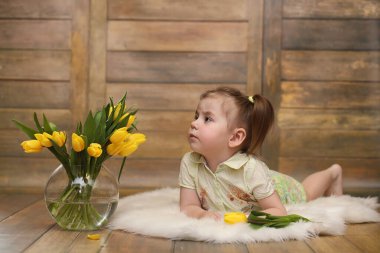 Bir buket Sarı laleler ile küçük bir çocuk. Bir çocuk bir hediye ile