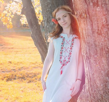 Bir parkta yürümek bir kız. Bahar Kızıl saçlı kız 