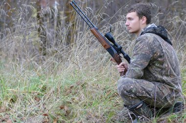 Kamuflaj ve bahar hun üzerinde orman Kuşağı'nda silahlı adam