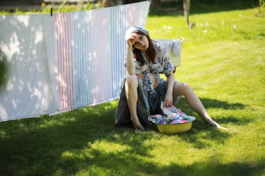 Hamile kadın yıkama giysi kurutma için ip üzerinde asılı