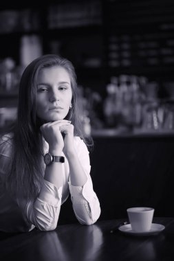 Bir kız bir kafede kahve içiyor. Bir kadın kahvaltı yapıyor