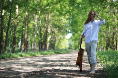 Yaz günü açık havada gitarı olan bir adam.