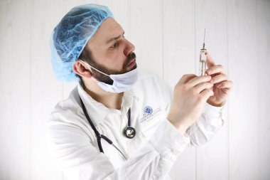 Beyaz önlük ve eski şırınga çılgın sakallı doktor