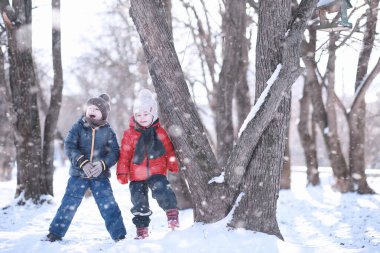 Çocuklar parkta kuşları besler. 