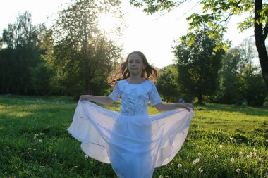 Bir bahar parkta bir karahindiba çiçek tohumlarından üfleme teen