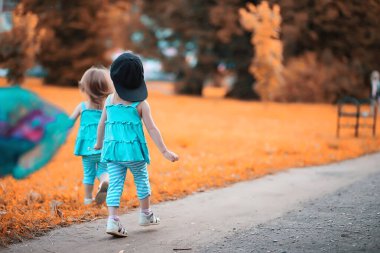 Parkta yürüyen iki ikiz kız.