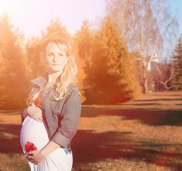 Menina grávida em um passeio no parque. Menina com uma barriga na ci — Fotografia de Stock