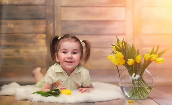 Uma criança pequena com um buquê de tulipas amarelas. Um rapaz com um dom — Fotografia de Stock