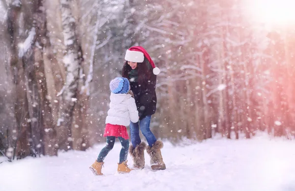 A winter fairy tale, a young mother and her daughter ride a sled