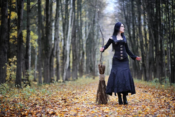 Une femme en costume de sorcière dans une forêt — Photo