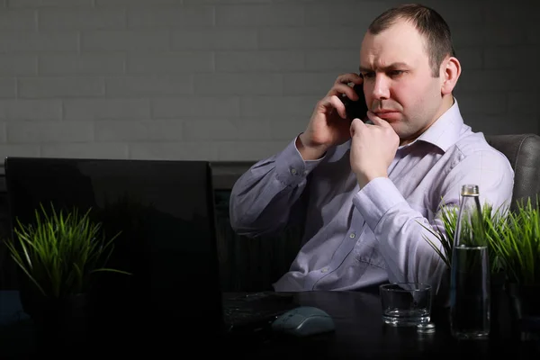 Homme assis à table et travaillant sur un ordinateur portable — Photo