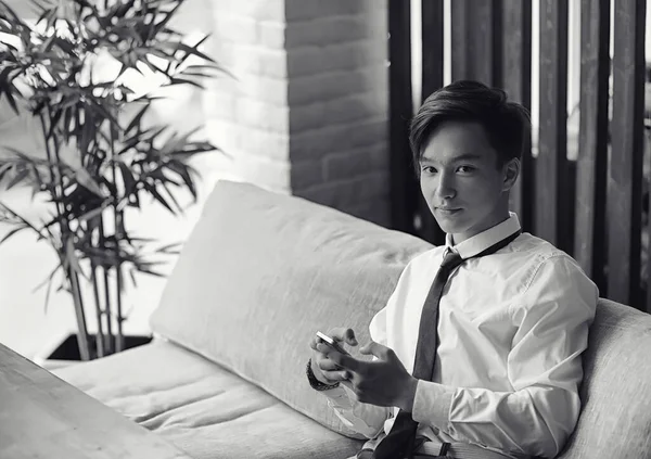 Genç Asyalı işadamı bir kafede bir ortak için bekliyor. Bu