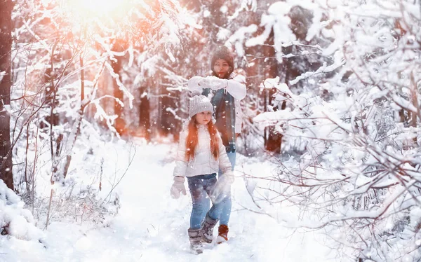 Una familia joven para dar un paseo. Mamá y su hija están caminando en un winte — Foto de Stock