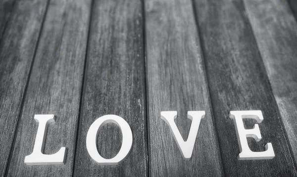 Mot amour composé de lettres blanches en bois sur un fond en bois — Photo
