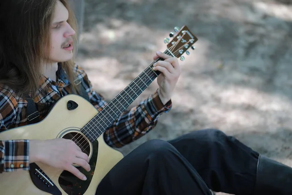 Um homem com uma guitarra no dia de verão ao ar livre — Fotografia de Stock