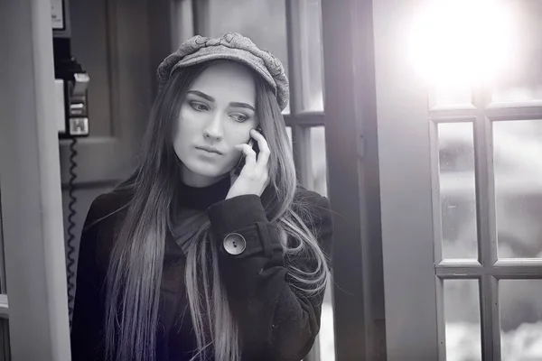 Menina bonita em uma cabine telefônica. A menina está falando no th — Fotografia de Stock