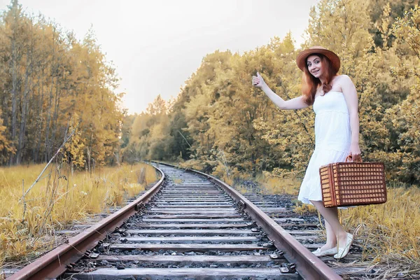 Herbst Park Mädchen in weißer Kleidung und einem Weidenkoffer zu Fuß — Stockfoto