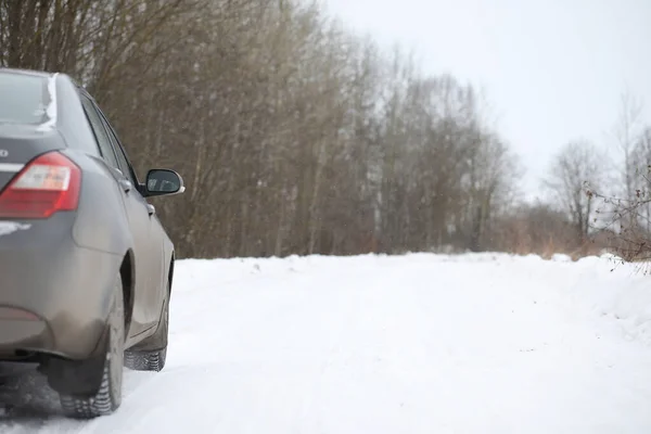 在田野上雪地冬天路上的汽车. — 图库照片