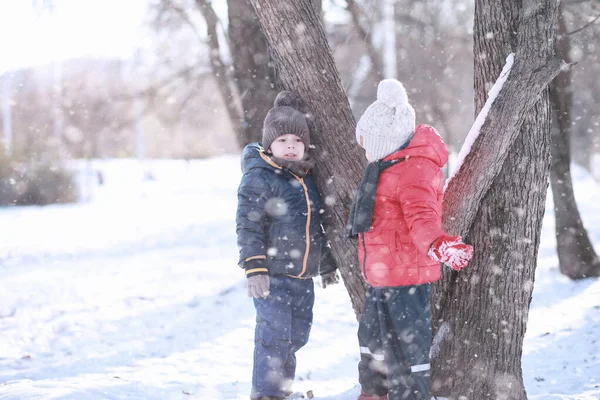 Çocuklar parkta kuşları besler. 
