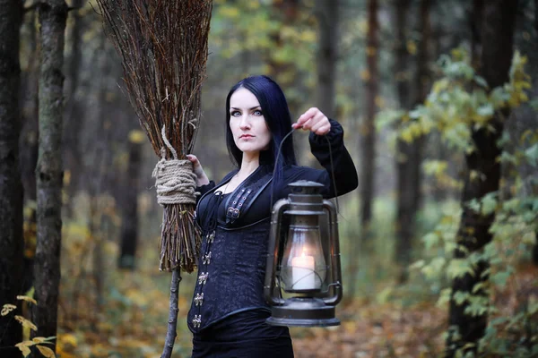 Une femme en costume de sorcière dans une forêt — Photo