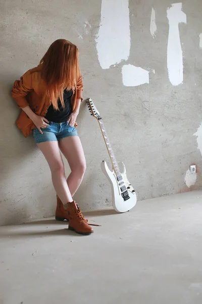 Menina ruiva jovem com uma guitarra elétrica. Músico de rock gir — Fotografia de Stock