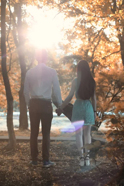 Pareja joven en un paseo en el parque de otoño — Foto de Stock