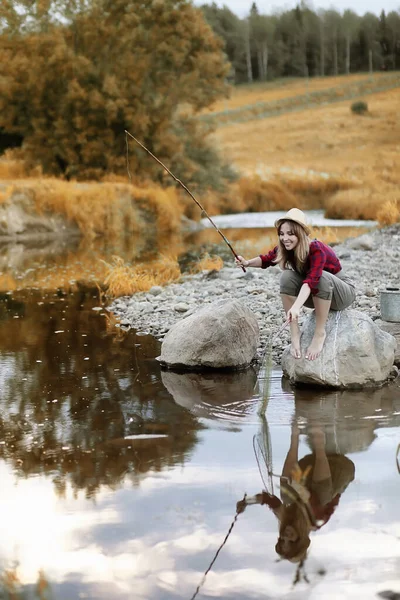 Ragazza in autunno con una canna da pesca — Foto Stock