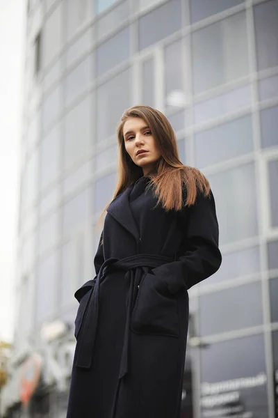 Красивая девушка в пальто в деловом центре города — стоковое фото