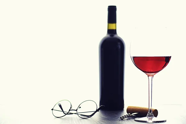A glass of red dry wine on the table. Dark bottle and glass of w — Stockfoto