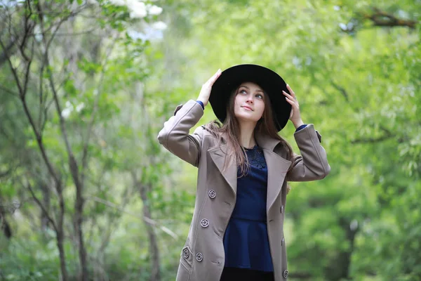 Chica joven en un abrigo en un parque de primavera —  Fotos de Stock