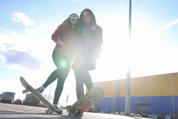 Uma jovem hipster está montando um skate. Meninas namoradas f — Fotografia de Stock